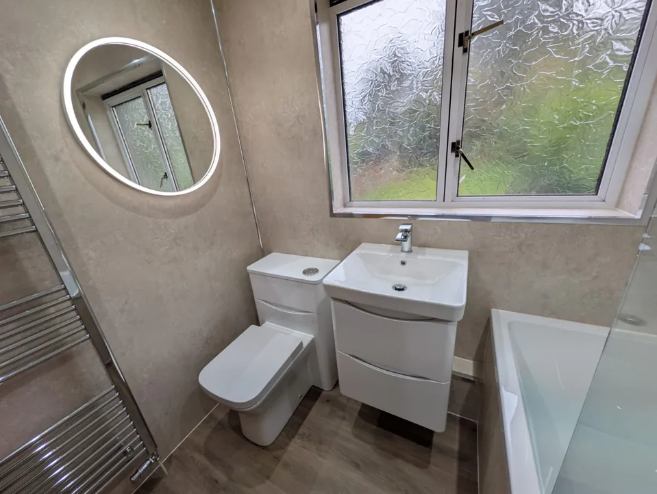 White vanity and toilet beside a fitted bath