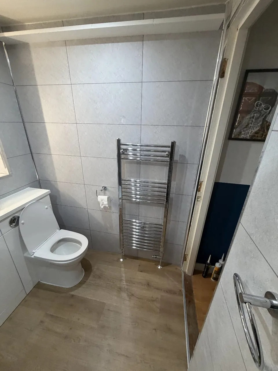 White bathroom furniture and a large illuminated mirror